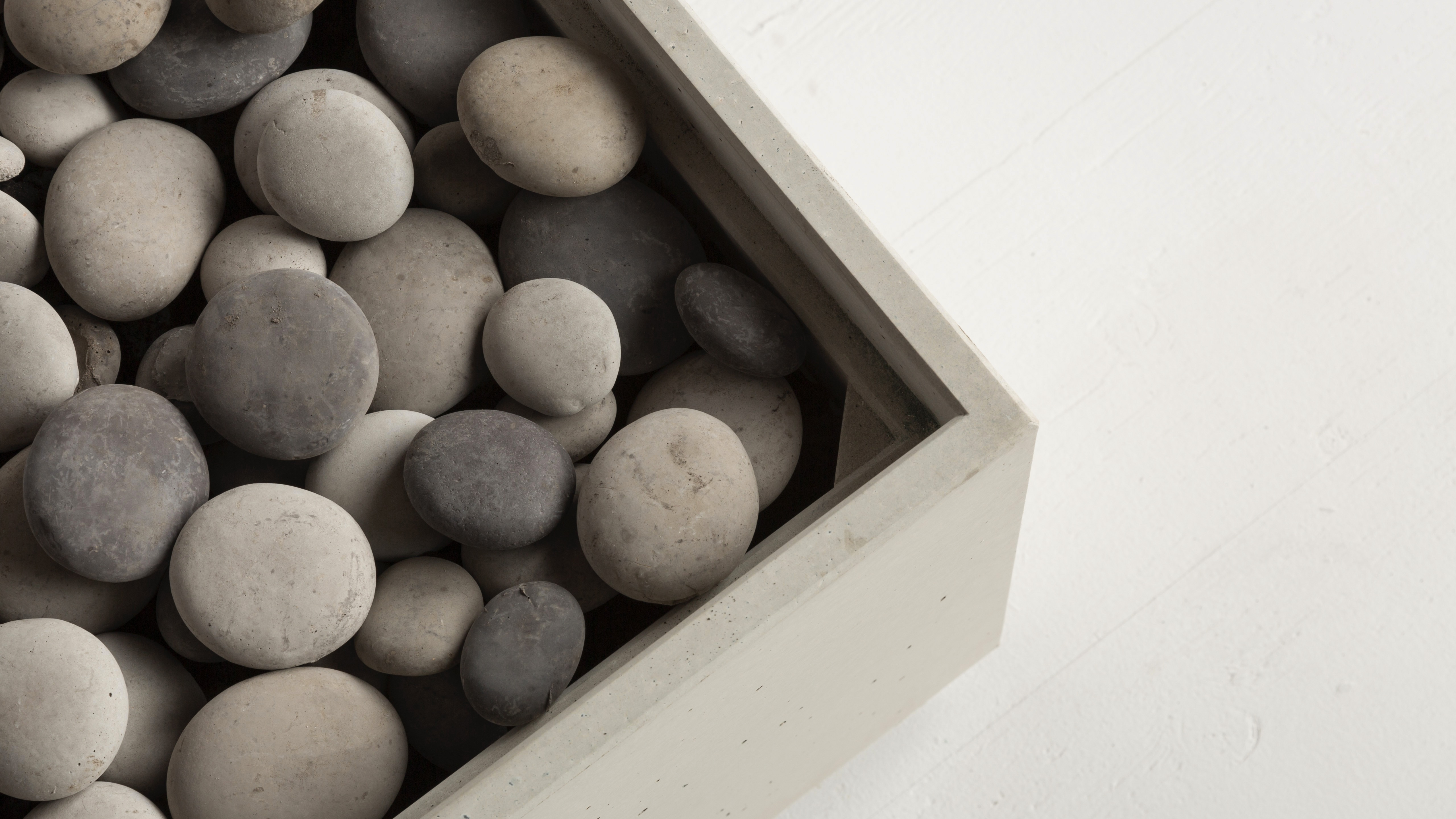 Solus Decor firestone arranged across the burner of a concrete gas fire pit
